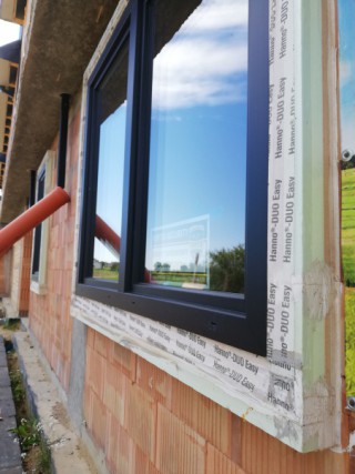Montaż okien PVC i HST ALU w kolorze Jet Black Mat w warstwie izolacji termicznej w ścianie z Porothermu Amar